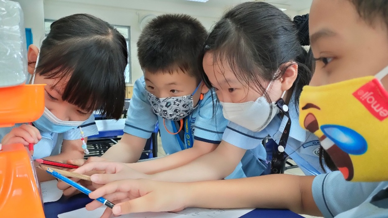 P2 students engaged in weighing an object together